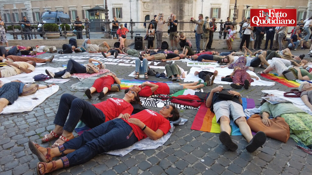 Tutti a terra davanti all’ingresso della Camera, il flash mob contro il riarmo. “Miliardi rubati alle nostre tasche”